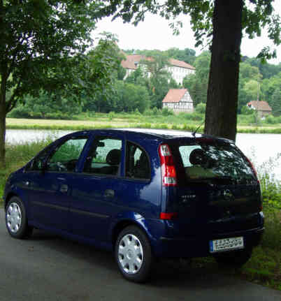 Opel Meriva unter Bäumen. 