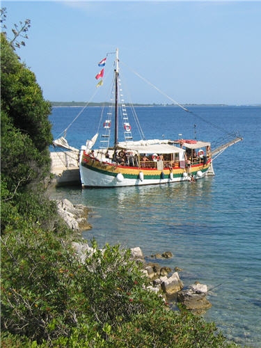 Das Ausflugsboot Kovren liegt an einem kleinen Steg. 