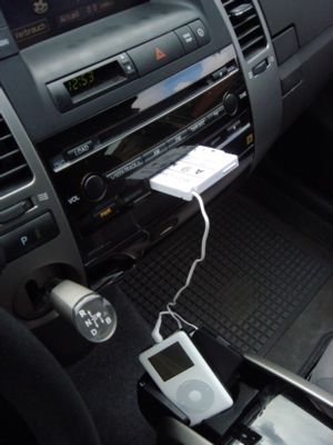 Der iPod im vorderen Getränkehalter ist über Kabel mit dem Kassettenadapter verbunden. 
